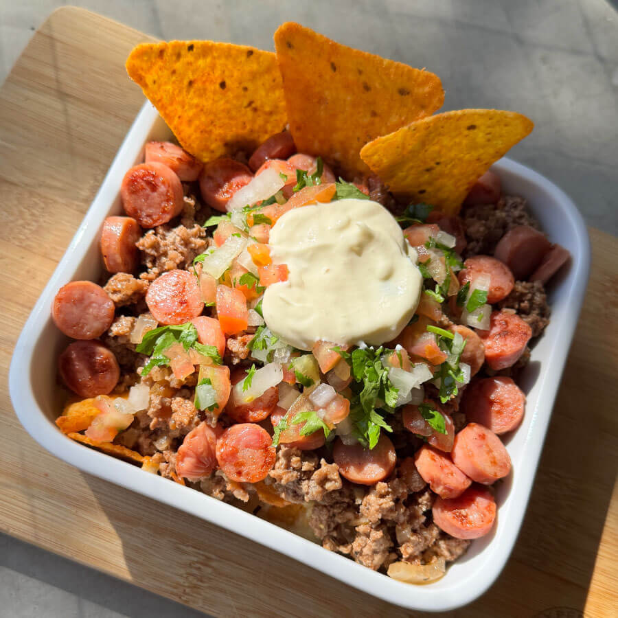 Dorilocos con Salchicha Desayuno Premium Fazán, carne molida, queso mozzarella fundido, pico de gallo y crema agria, servidos como un pasabocas fácil para compartir.