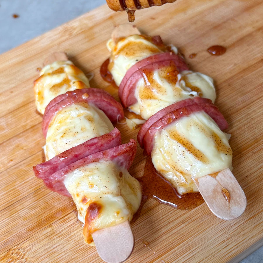 Pinchos de queso asado con Cervecerito Premium Fazán acompañados con miel, páprika y pimienta.