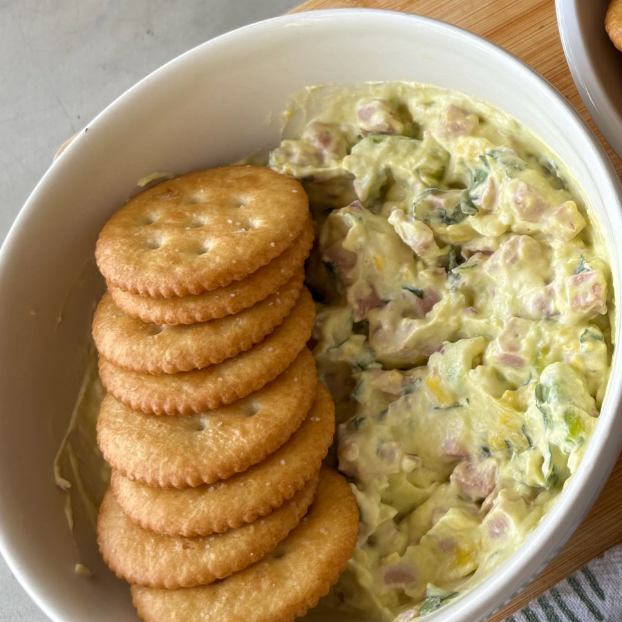 Dip cremoso con Salchichón Auténtico Fazán, queso crema, aguacate, cebolla morada y cilantro.